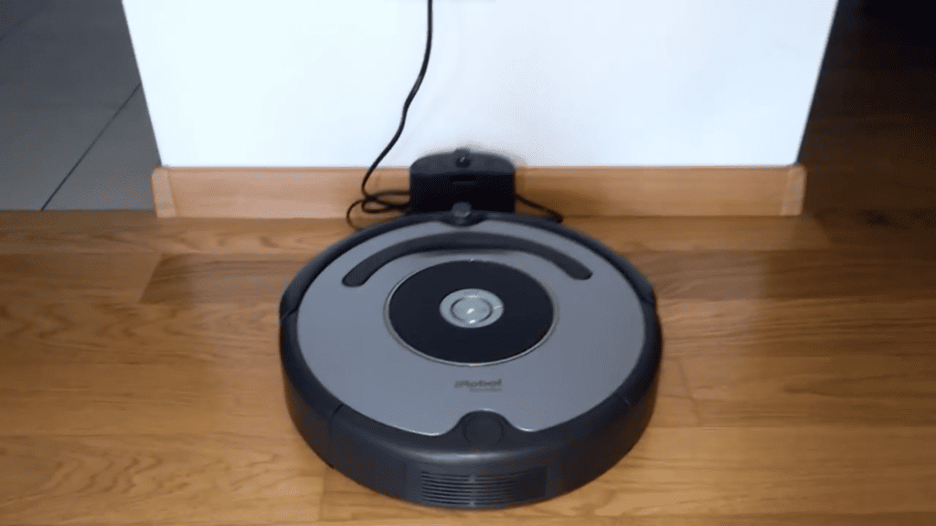 Le Roomba 615 à coté de sa station de recharge