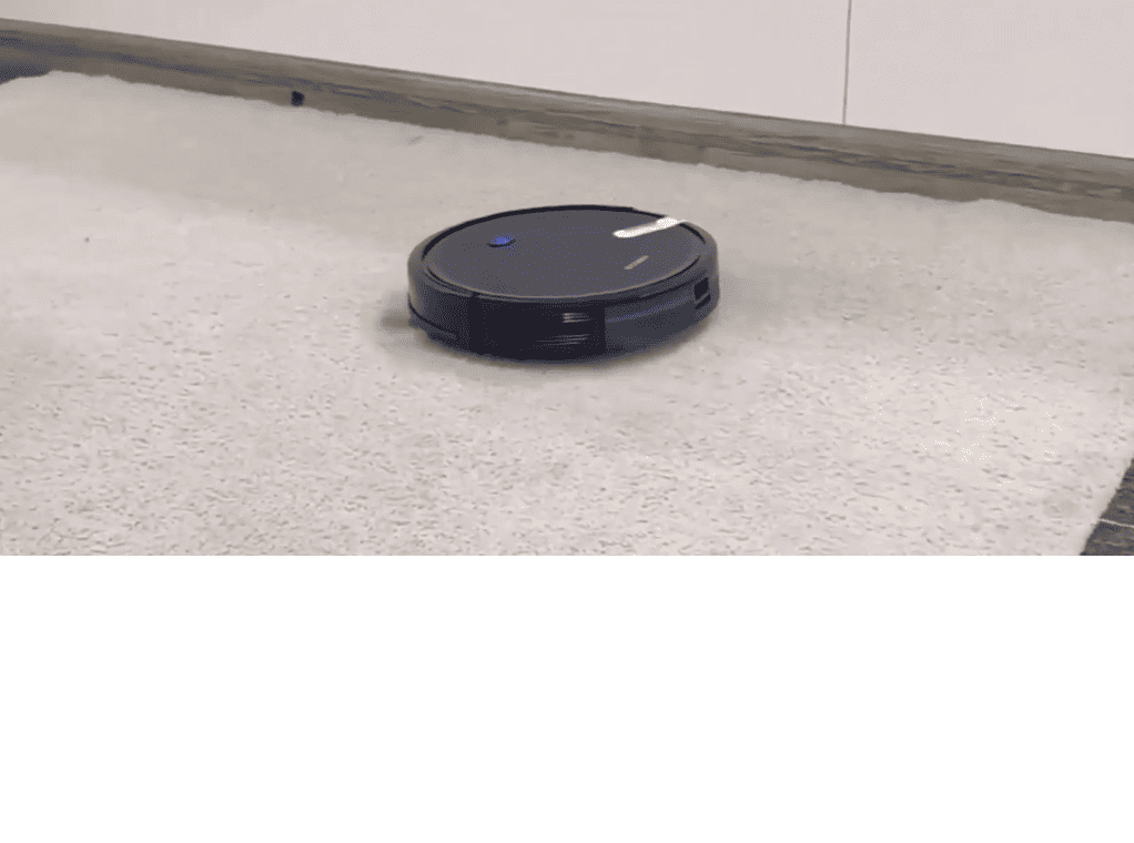 Un robot aspirateur posé sur le sol d'une pièce.