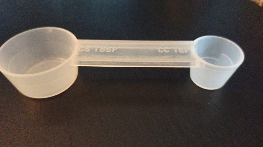 Une tasse à mesurer en plastique sur une table.