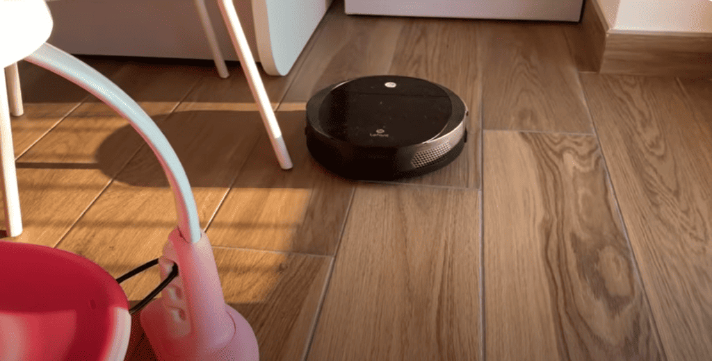 Un robot aspirateur sur le sol d'une cuisine - Aspirateur robot Lefant M213 avis.